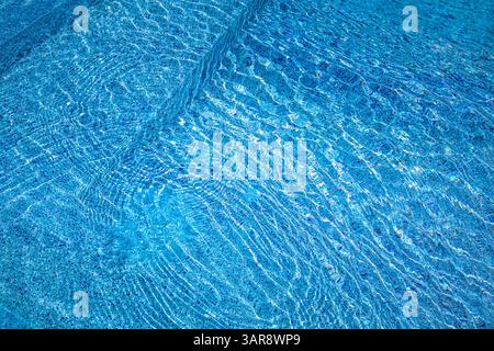 Vue rapprochée de l'eau abstraite de la piscine avec lumière d'été ondulante parfaite pour les arrière-plans design, les vibrations rafraîchissantes d'inspiration tropicale créative Banque D'Images