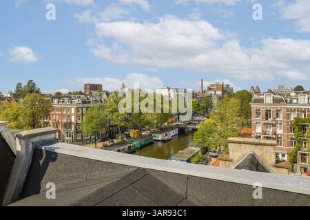 L'image montre une vue aérienne pittoresque d'Amsterdam, avec ses canaux emblématiques, sa végétation luxuriante et son architecture historique charmante. Banque D'Images