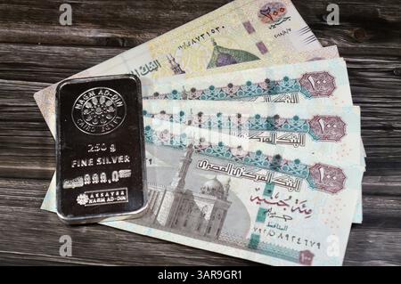 Le Caire, Egypte, 21 février 2025 : billets de banque en livres égyptiennes et lingot ad-DIN pur argent fin 250 grammes barre, investissement en argent, taux de change Banque D'Images