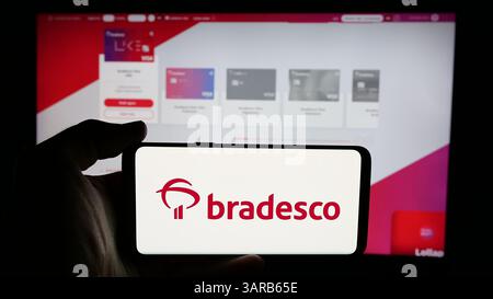 Stuttgart, Allemagne - 2024 : personne tenant un téléphone portable avec le logo de la société bancaire brésilienne Banco Bradesco sa sur l'écran Banque D'Images