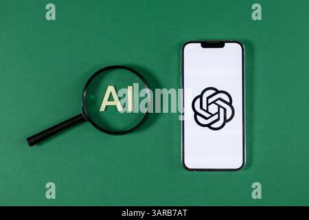 Poznan, Pologne – 14 avril 2025 : lettres ai en bois vues à travers une loupe placée à côté du smartphone avec le logo Chat GPT, symbolisant l'accent sur l'artificia Banque D'Images