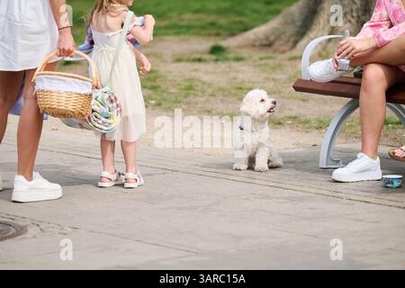 Berlin, Allemagne. 17 avril 2025. Dans la vieille ville de Köpenick, une mère et sa fille reviennent d’un pique-nique et discutent avec des amis pendant que Nun Toffee est assise avec eux. Crédit : Annette Riedl/dpa/Alamy Live News Banque D'Images
