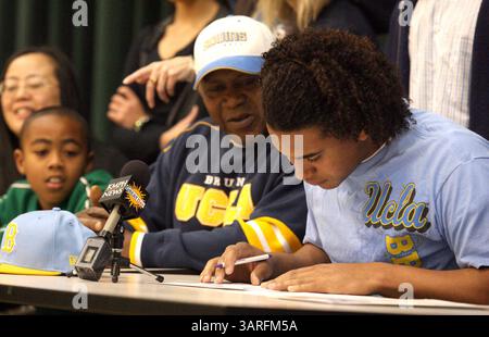 03 février 2010 - Fresno, California, USA - Fresno, CA 2-3-2010- SPT JRW KENDRICKS SIGNE - comme neveu Nathan Kendricks, 10 ans, extrême gauche, et papa, Marvin Kendricks, centre, regardez, Eric Kendricks de Hoover High s'apprête à signer pour jouer au football à UCLA, mercredi matin, au centre des événements spéciaux de Hoover High..John Walker/The Fresno Bee (crédit image : © Fresno Bee/ZUMApress.com) Banque D'Images