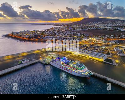 Lanzarote. Îles Canaries, Espagne. 02.02.2025 superbe coucher de soleil au-dessus de Playa Blanca tandis qu'un ferry Armas attend au port. 2 février 2025. Banque D'Images