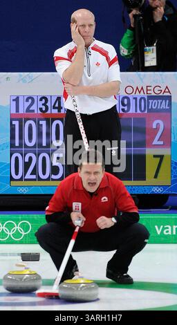 19 février 2010 - Vancouver, BC, Canada - VANCOUVER, BC : 19 FÉVRIER 2010 -- le capitaine canadien Kevin Martin (arrière) regarde le capitaine danois Ulrik Schmidt crier au cinquième bout du tournoi olympique masculin de curling au Centre olympique de Vancouver le jour 8 des Jeux olympiques d'hiver de 2010 à Vancouver le 19 février 2010. Le Canada a ensuite gagné le match 10-3 en six bouts. (RIC Ernst / Canwest News Service). CNS-OLY-CURL (crédit image : © CanWest/ZUMApress.com) Banque D'Images