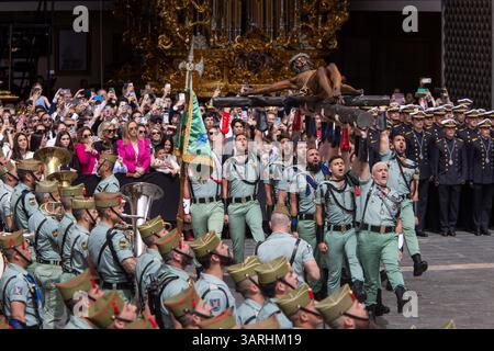 Un groupe de légionnaires porte le Christ de Mena lors du transfert du Christ de Mena le jeudi Saint, l'une des processions les plus célèbres de la semaine Sainte dans toute l'Espagne, à la fois pour ce qu'elle représente et pour la participation de la Légion en chantant 'El Novio de la Muerte', une chanson emblématique qui est devenue l'hymne officieux de la Légion espagnole. Banque D'Images