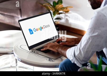 Homme utilisant un ordinateur portable affichant le logo de Google Docs sur l'écran. ROSARIO, ARGENTINE - 17 AVRIL 2025 Banque D'Images