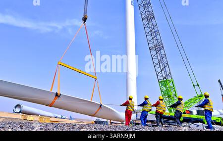 ZHANGYE, CHINE - 17 AVRIL 2025 - sur le site de construction du projet éolien de 100 000 kilowatts de Xinruisheng New Energy à Yanchi Beach, les constructeurs assemblent des pales d'éoliennes dans la ville de Zhangye, province du Gansu, Chine, le 17 avril 2025. Banque D'Images