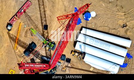 ZHANGYE, CHINE - 17 AVRIL 2025 - sur le site de construction du projet éolien de 100 000 kilowatts de Xinruisheng New Energy à Yanchi Beach, des constructeurs lèvent les tours d'éoliennes dans la ville de Zhangye, province du Gansu, Chine, le 17 avril 2025. Banque D'Images
