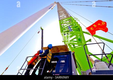 ZHANGYE, CHINE - 17 AVRIL 2025 - sur le site de construction du projet éolien de 100 000 kilowatts de Xinruisheng New Energy à Yanchi Beach, des constructeurs lèvent les tours d'éoliennes dans la ville de Zhangye, province du Gansu, Chine, le 17 avril 2025. Banque D'Images