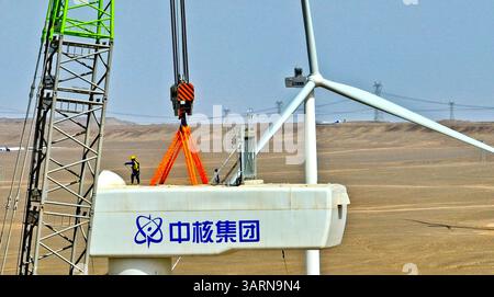 ZHANGYE, CHINE - 17 AVRIL 2025 - sur le site de construction du projet éolien de 100 000 kilowatts de Xinruisheng New Energy à Yanchi Beach, les constructeurs installent l'unité principale de l'éolienne sur une tour de 120 mètres de haut dans la ville de Zhangye, province du Gansu, Chine, le 17 avril 2025. Banque D'Images