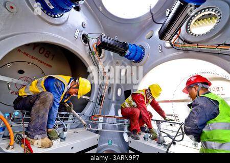 ZHANGYE, CHINE - 17 AVRIL 2025 - sur le site de construction du projet éolien de 100 000 kilowatts de Xinruisheng New Energy à Yanchi Beach, les constructeurs assemblent des pales d'éoliennes dans la ville de Zhangye, province du Gansu, Chine, le 17 avril 2025. Banque D'Images