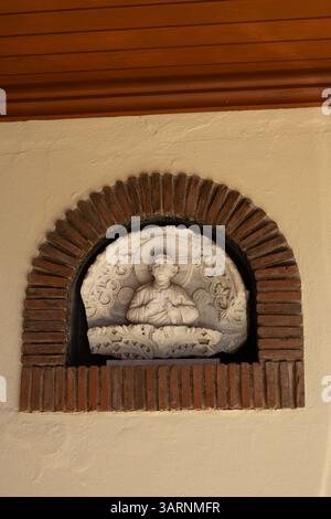 Ancien relief religieux en marbre dans la niche de Brick Arch Banque D'Images