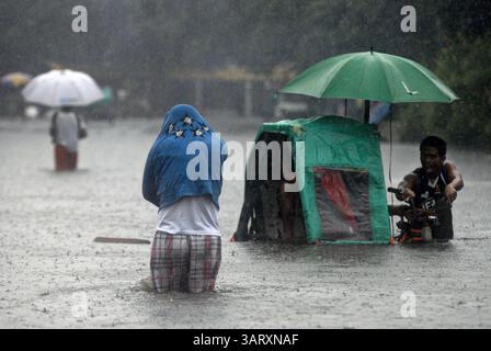 20 août 2013 - Manille, Philippines - les Philippins patèrent dans les eaux de crue à Manille, Philippines, le 20 août 2013. Les fortes pluies intensifiées par la tempête tropicale Trami se sont poursuivies pendant un deuxième jour, provoquant une hausse des niveaux d'eau et poussant des milliers de personnes vivant dans les zones basses à fuir leurs foyers. (Crédit image : © Ezra Acayan/ZUMAPRESS.com) Banque D'Images