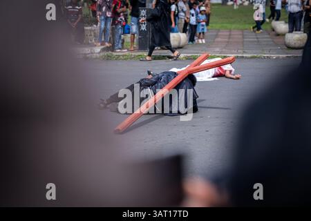 Les dévots prennent part à une procession du vendredi Saint, marchant à travers la ville dans un rituel solennel riche en éléments culturels catholiques et traditionnels locaux. Banque D'Images