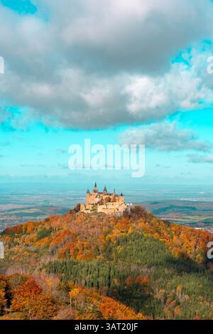 Hechingen, Bade-Württemberg, Allemagne - 22 octobre 2021 : image verticale avec le château de Hohenzollern entouré d'une forêt d'automne sous un ciel bleu Banque D'Images