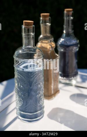 Bouteilles en verre décoratives remplies de sable coloré pour ce mariage Banque D'Images