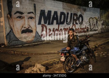19 juillet 2013 - Caracas, Miranda, Venezuela - Un habitant du bidonville de Petare dans l'est de Caracas attend que sa carte d'identité soit vérifiée par la police. Petare est l'un des plus grands bidonvilles d'Amérique du Sud avec plus d'un demi-million d'habitants, et est un foyer de criminalité à Caracas, qui est actuellement l'une des villes les plus dangereuses de la planète. (Crédit image : © Charles Mostoller/ZUMAPRESS.com) Banque D'Images