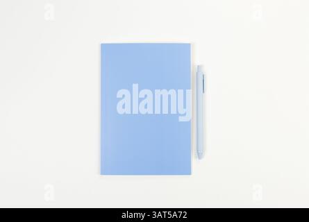 Vue de dessus du carnet bleu, stylo bleu sur fond blanc. École, papier peint de bureau. Pose à plat, espace de copie. Banque D'Images