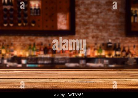 Comptoir de bar en bois vide avec mur de briques défocalisé avec bouteilles d'alcool, espace de copie pour le placement des produits Banque D'Images