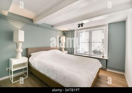 Une chambre moderne magnifiquement conçue avec des couleurs douces et un décor minimaliste, créant une atmosphère sereine et accueillante parfaite pour la détente. Banque D'Images