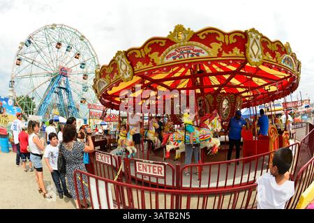 10 août 2013 - Brooklyn, New York, États-Unis - les enfants montent sur les chevaux de carrousel à Luna Park, avec la Wonder Wheel en arrière-plan, lors de la 3e célébration annuelle de la Journée de l'histoire de Coney Island. Prise avec un objectif fisheye à 180 degrés. (Crédit image : © Ann Parry/ZUMA Wire) Banque D'Images