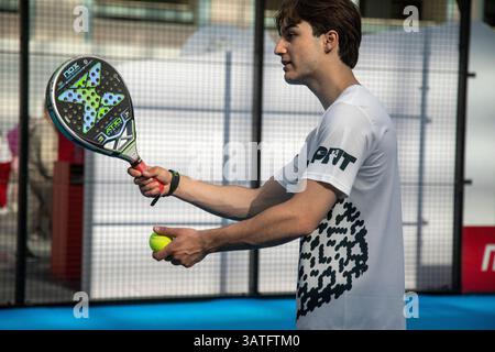 Moscou, Russie. 18 avril 2025. Un jeune homme servant le ballon tout en jouant au padel dans le court pendant l'entraînement sur un site de la foire sportive 'My Sport' à Gostiny Dvor à Moscou, en Russie Banque D'Images