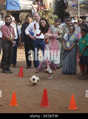10 avril 2016 - Mumbai, INDE - le prince William, de Grande-Bretagne, regarde son épouse Kate, la duchesse de Cambridge, jouer au football lors de leur visite dans un bidonville de Mumbai, Inde, le dimanche 10 avril 2016. Le couple royal a commencé sa visite d'une semaine en Inde et au Bhoutan, en déposant une couronne lors d'un dimanche commémoratif à l'emblématique hôtel Taj Mahal Palace de MumbaiÃÂ­s, où 31 victimes des attentats terroristes de Mumbai en 2008 ont été tuées. (Crédit image : © Prensa Internacional via ZUMA Wire) Banque D'Images