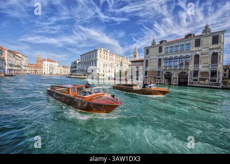 Les bateaux-taxis en bois passent devant le Palazzo Capello Malipiero (à droite) et le Palazzo Grassi près de la jetée de San Samuele, sur le Grand canal, San Marco, Venise Banque D'Images
