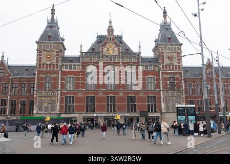 Amsterdam, pays-Bas, le 9 février 2025 : touristes et habitants marchant et se déplaçant devant la gare centrale d'amsterdam, hollande du nord, pays-bas Banque D'Images