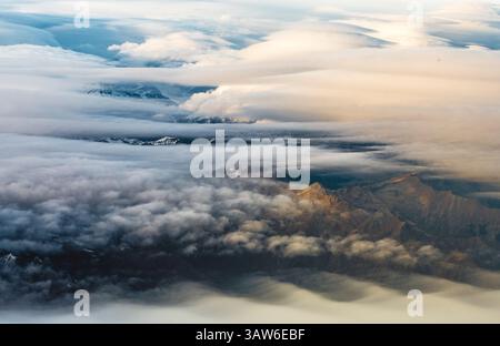 Vue aérienne des Alpes françaises sous un voile de nuages en route de Milan à Londres. Banque D'Images