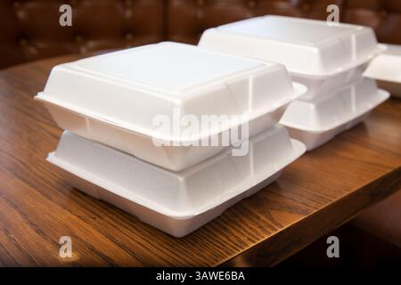 Une vue de piles de boîtes à emporter en polystyrène sur une table de restaurant. Banque D'Images