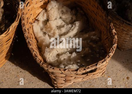 Gros plan de laine fraîchement cisaillée dans un panier tissé éclairé par le soleil de l'après-midi à Middleton place Plantation à Charleston, Caroline du Sud. Banque D'Images