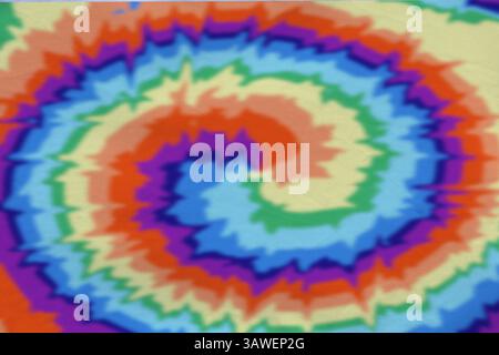 Tissu brillant teint avec la technique de tie-dye. Textile avec des tourbillons dans des couleurs arc-en-ciel Banque D'Images