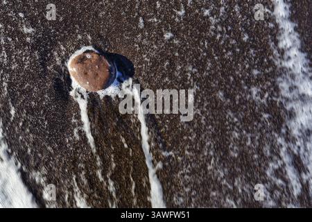 Galet simple sur la plage de lave noire, eau drainante, bord de mer, détail, espace libre de texte, motion blur, Playa Quemada, Yaiza, Lanzarote, Espagne, Europe Banque D'Images