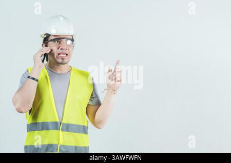 Jeune ingénieur latin appelant au téléphone isolé. Ingénieur civil parlant téléphone isolé Banque D'Images