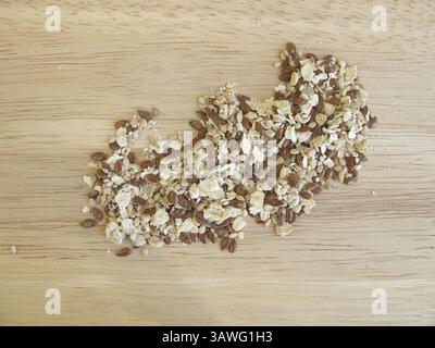Mélange de graines avec flocons d'avoine, graines de lin et graines de sésame sur une planche de bois Banque D'Images