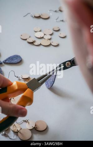 Femme fabriquant des boucles d'oreilles ou des bijoux Banque D'Images