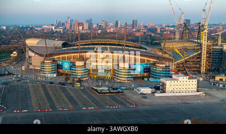Image aérienne panoramique du stade Etihad (Manchester City FC) et de la ligne d'horizon de la ville touchée par le lever du soleil du matin. Banque D'Images