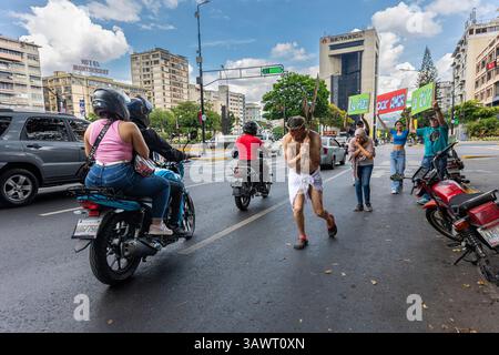 Un homme dans une représentation de Jésus-Christ traverse un passage pour piétons dans une rue de Caracas. Banque D'Images