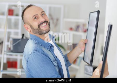 homme accrochant une affiche vierge dans le hall d'exposition Banque D'Images