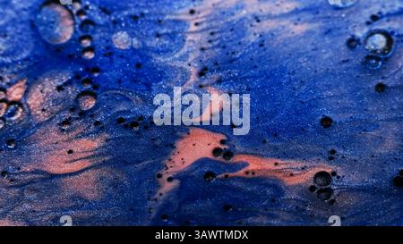 Flux de mélange d'encre. Éclaboussure de liquide scintillant. Peinture de couleur bronze bleu défocalisé dans des bulles d'huile d'eau se répandant sur fond de marbre abstrait. Banque D'Images