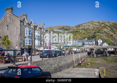 Cafés et boutiques sur le quai au port à marée basse à Barmouth, pays de Galles, le 9 avril 2025 Banque D'Images