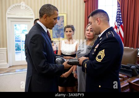 12 juillet 2011 - Washington, District of Columbia, États-Unis - le sergent de première classe de l'armée américaine Leroy Petry montre au président Barack Obama une plaque avec les noms des Rangers tombés du 75e régiment sur sa prothèse de bras lors d'une réunion le 12 juillet 2011 dans le bureau ovale de la Maison Blanche. Le président a ensuite décerné au SFC Petry la Médaille d'honneur pour ses actions courageuses lors d'opérations de combat contre un ennemi armé à Paktya, en Afghanistan, en mai 2008. (Crédit image : © Pete Souza/la Maison Blanche/ZUMAPRESS.com) Banque D'Images