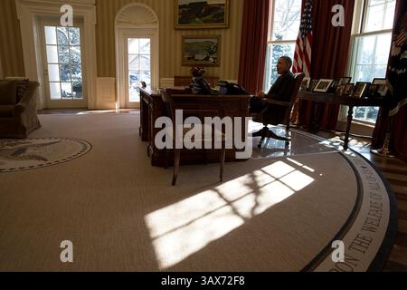 17 février 2015 - Washington, DC, États-Unis d'Amérique - le président américain Barack Obama est assis au Resolute Desk alors que le soleil se jette dans le bureau ovale de la Maison Blanche le 17 février 2015 à Washington, DC. Barack Hussein Obama II (né le 4 août 1961) est le 44e président des États-Unis. Il est le premier Afro-américain à être élu et le premier président né en dehors des États-Unis contigus. Né à Honolulu, Hawaï, Obama est diplômé de l'Université Columbia et de la Harvard Law School. Il a travaillé comme avocat des droits civils et a enseigné le droit constitutionnel à l'Université o Banque D'Images