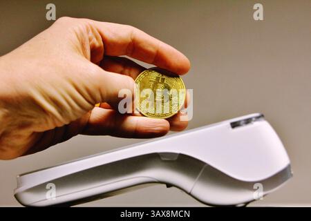 Client payant avec la crypto-monnaie bitcoin en utilisant la technologie nfc sur le terminal pos Banque D'Images