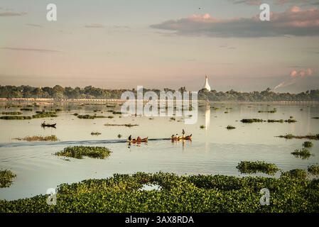 Pêcheurs dans des bateaux tôt le matin sur le lac Taungthaman près d'Amarapura au Myanmar Banque D'Images
