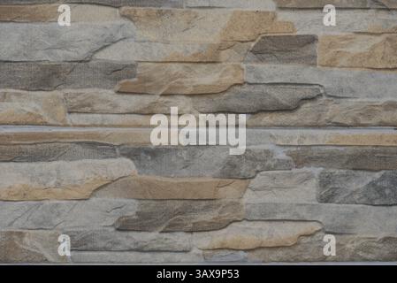 Mur de pierre avec une surface relativement lisse et des pierres colorées Banque D'Images