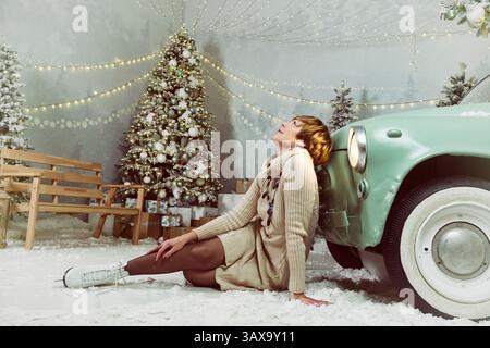 Une femme adulte boit du champagne sur une patinoire la veille du nouvel an tout en patinant à côté d'un arbre de Noël Banque D'Images