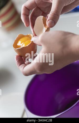 Surprise lors de l'ouverture d'un œuf avec deux jaunes - gros plan Banque D'Images